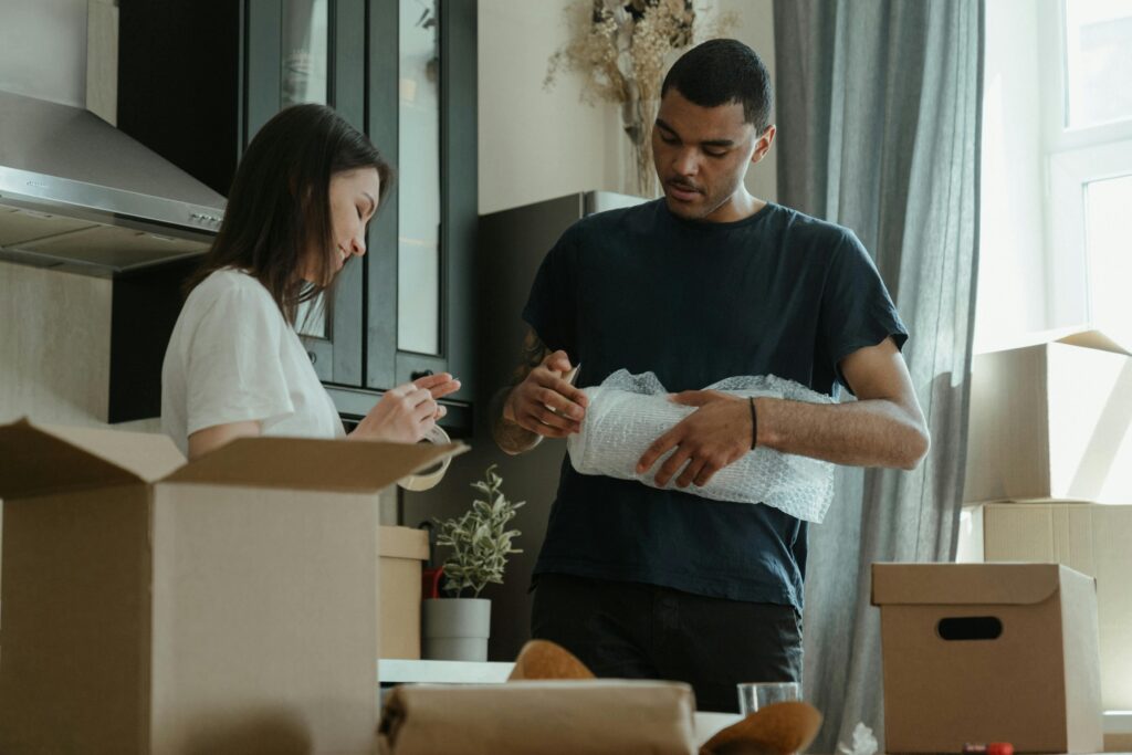Man en vrouw verhuizen kamer in met kartonnen dozen - illustratie van verborgen risico's bij verhuizen